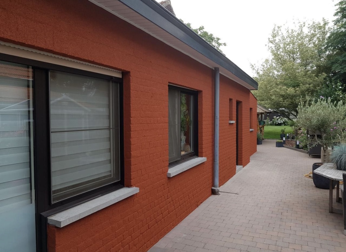 Terracotta spray cork finish on a brick house facade